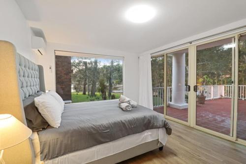 a bedroom with a bed and a large window at Grand Esplanade in North Arms Cove