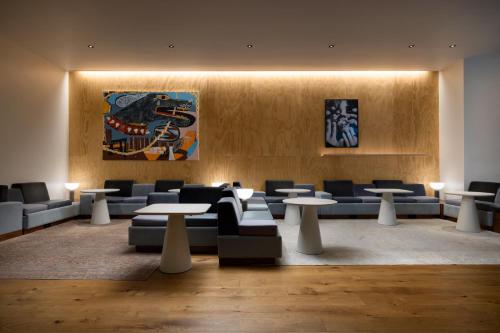 a lobby with couches and tables and a painting at Timbri Hotel San Francisco, Curio Collection by Hilton in San Francisco