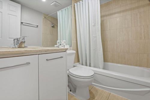 a bathroom with a toilet and a tub and a sink at Central 1bedroom apartment in Montréal