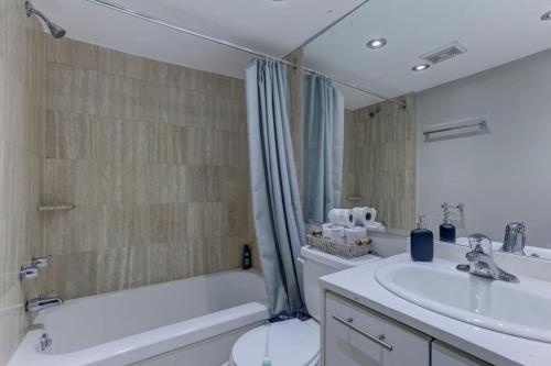a bathroom with a sink and a tub and a toilet at Cozy condo in heart of downtown Montreal in Montréal