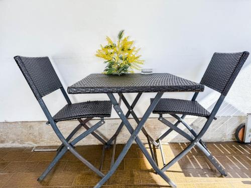 a table with two chairs and a plant on it at Villa Mimosa in Cassano Magnago