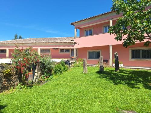 a pink house with a yard in front of it at Quinta das Carvalhas in Neiva