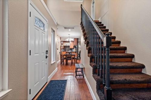 a hallway with a staircase with a door and a dining room at Huge House-Yard-Pool Hot Tub in Citrus Heights