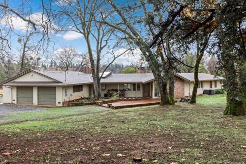 a house with a yard with trees in front of it at Mid-Century-Modern Mountain Gem in Placerville