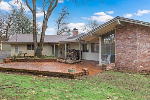 a brick house with a patio and a tree at Mid-Century-Modern Mountain Gem in Placerville