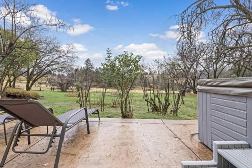 a patio with a bench and a view of a field at Mid-Century-Modern Mountain Gem in Placerville
