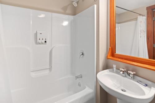 een witte badkamer met een wastafel en een spiegel bij Rimfire 150 in Slaty Fork