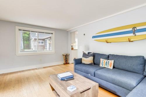 a living room with a blue couch and a surfboard on the wall at 509 Massive 3 bedroom with gorgeous pool in Hampton Bays