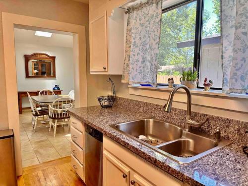a kitchen with a sink and a dining room at The Virginia Blue- Walk To Downtown Prescott in Prescott