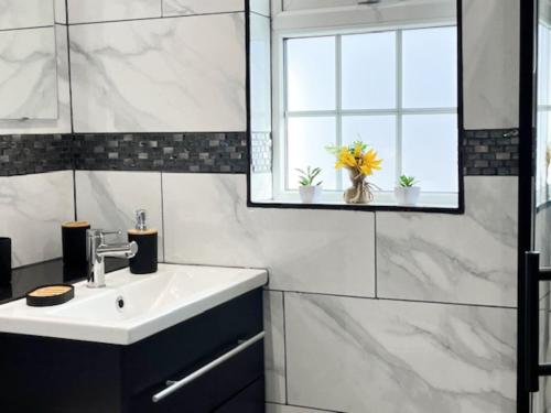 a bathroom with a sink and a mirror and a window at Luxury and spacious 3 bedroom home in Southampton in Southampton