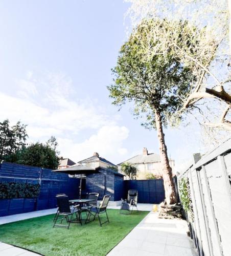 a patio with a table and chairs and a tree at Luxury and spacious 3 bedroom home in Southampton in Southampton