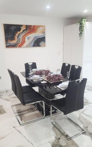 a dining room table with black chairs and a painting at Luxury and spacious 3 bedroom home in Southampton in Southampton