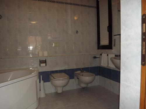 a bathroom with a tub and a toilet and a sink at Hotel Cristina in Chianciano Terme