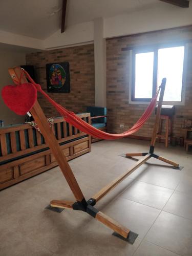 a wooden stand with a red rope in a room at Quinta las Marias, Ecolodge, camping y Tiny wood house in Guateque