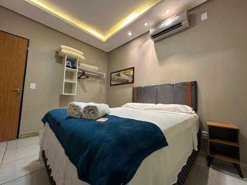 a bedroom with a large bed with a blue blanket at Conforto - Casa completa com ar-cond - Wi-Fi in Trindade