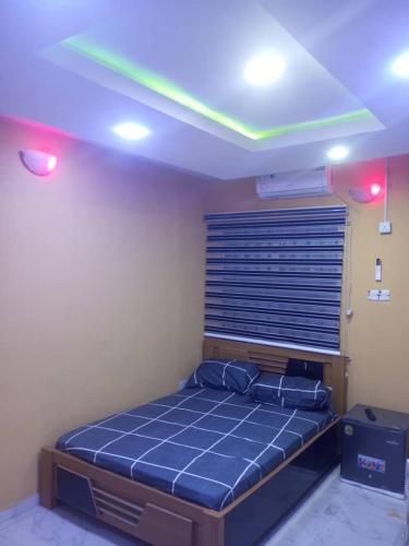 a bedroom with a bed in a room with lights at Fehintola Apartment in Abeokuta