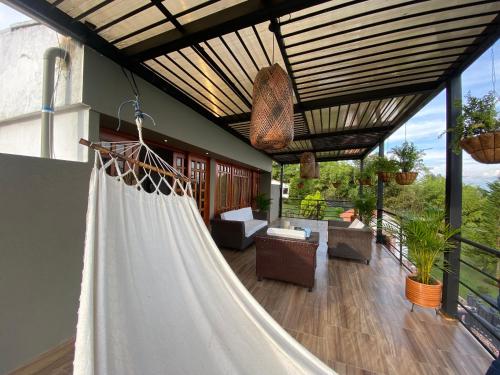 a hammock on a house with a patio at Villa Fátima dapa in Yumbo