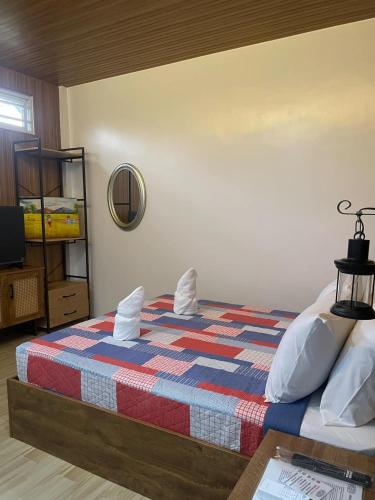 a bedroom with a bed with a colorful blanket at Casa De Española Hotel and Resort in Aritao