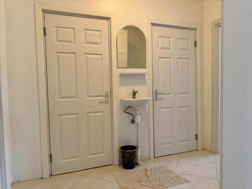 a bathroom with two white doors and a sink at 2 Slaapkamer Appartement in Paramaribo-Noord in Paramaribo