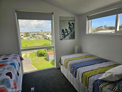 a bedroom with two beds and a window at Pyramid beach house in Karikari Peninsula