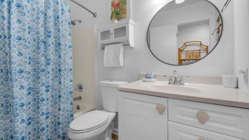 Beachside Condo 13 في شاطئ سانتا روزا: حمام مزود بمرحاض ومغسلة ومرآة