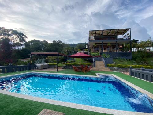 a swimming pool with a house in the background at Villa Fátima dapa in Yumbo