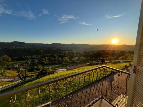 a view of the sunset from the balcony of a house at Residencial Encantos Linha Bonita - Vista que acalma, ambiente que encanta! in Gramado