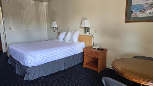 a hotel room with a bed and a table at Terrace Inn and Suites in El Cerrito