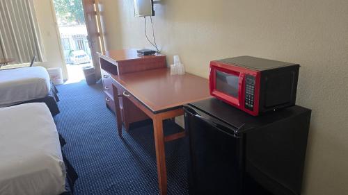 a room with a desk with a red microwave on it at Terrace Inn and Suites in El Cerrito