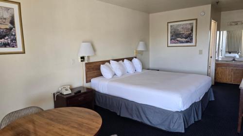 a hotel room with a bed and a table at Terrace Inn and Suites in El Cerrito