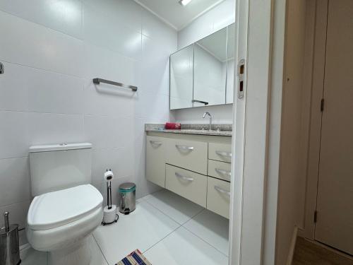 a white bathroom with a toilet and a sink at Aᴘᴀʀᴛᴀᴍᴇɴᴛo404, ᴄᴏᴍᴘʟᴇᴛᴏ ᴄᴏᴍ ᴇsᴛᴀᴄɪᴏɴᴀᴍᴇɴᴛᴏ, Wɪ-Fɪ, Gʏᴍ, Tᴠ Sᴍᴀʀᴛ, Cᴏᴡᴏʀᴋɪɴɢ - ᴘᴀʀᴀ ᴀᴛé ᴅᴜᴀs ᴘᴇssᴏᴀs in Sao Paulo