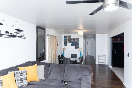 a living room with a gray couch and a dining room at Beautifully Designed & Spacious Apartment in Newark 10mins from EWR Airport, Close to NYC and Beth Israel Hospital in Newark