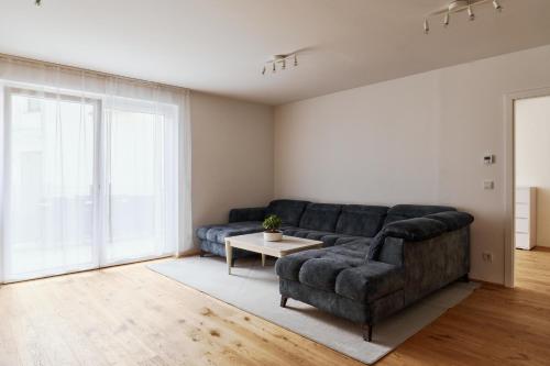 a living room with a couch and a table at Symphony Apartments Vienna - Garden, Terrace and Grill in Vienna
