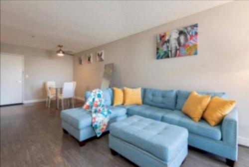 a living room with a blue couch and a table at Stylish Hollywood Hideaway 1Bed Rooftop Pool with Iconic View D in Los Angeles