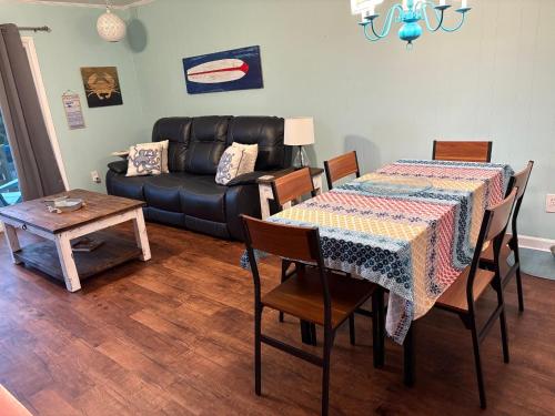 a living room with a table and a couch at Thats What Sea Said in Holden Beach