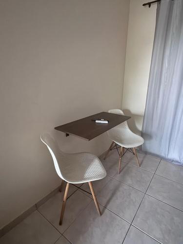 a table and two chairs in a room at Pousada Hostel Shalom in Rio das Ostras