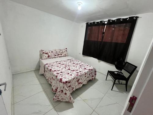 ein kleines Schlafzimmer mit einem Bett und einem Fenster in der Unterkunft Vila Negreiros Serra Negra Casa 1 in Bezerros