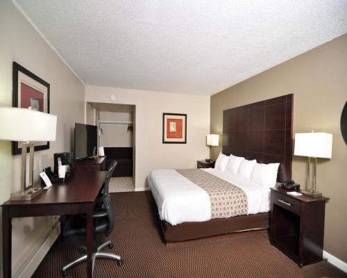 a hotel room with a bed and a desk and a computer at Baymont by Wyndham Sandusky in Sandusky