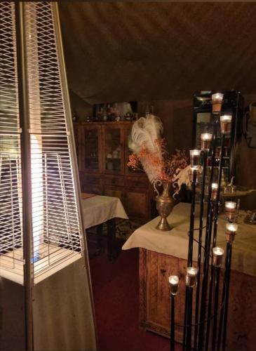 a room with a table and a vase with flowers at Infinity sahara camp in Merzouga