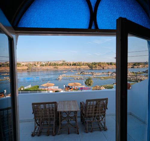 einen Balkon mit einem Tisch und Stühlen sowie Flussblick in der Unterkunft JAREEDY Guest house in Shellal