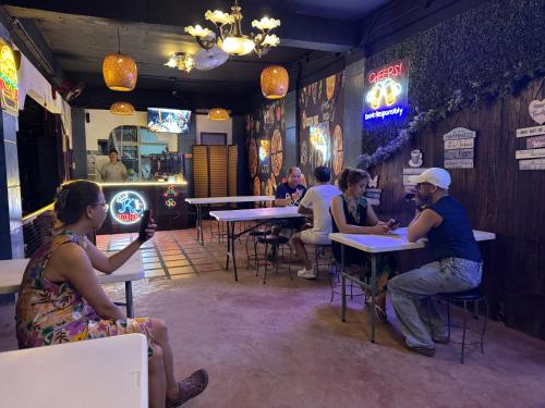 a group of people sitting at tables in a restaurant at BZ Hostel Cebu in Lapu Lapu City