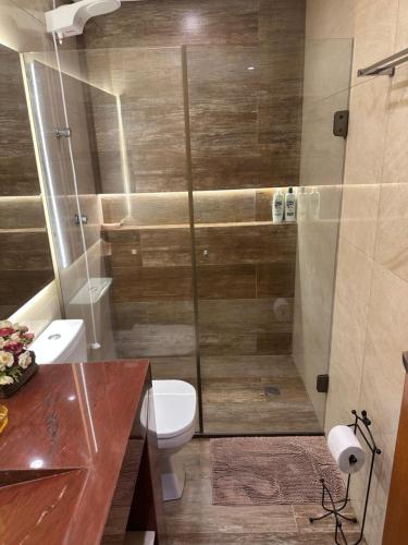 a bathroom with a toilet and a glass shower at Flat no Life Resort a Beira Lago in Brasilia
