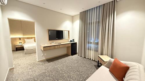 a hotel room with a couch and a television at فندق آرام النسيم in Ash Shishah