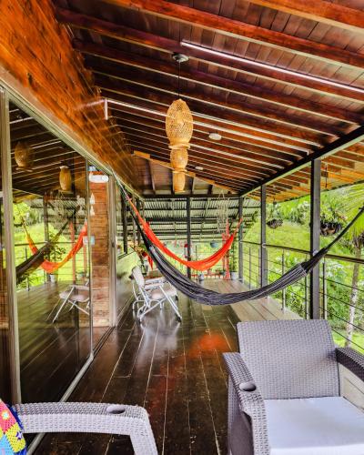 a hammock in the middle of a room with chairs at Casa Hotel La Cherna in Bahía Solano