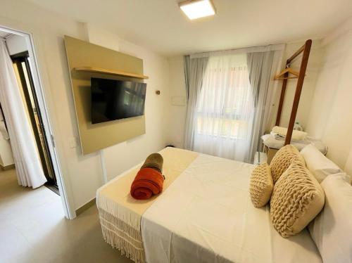 ein Schlafzimmer mit einem Bett und einem Fernseher an der Wand in der Unterkunft Térreo com 3 suítes beira-mar in São Miguel do Gostoso