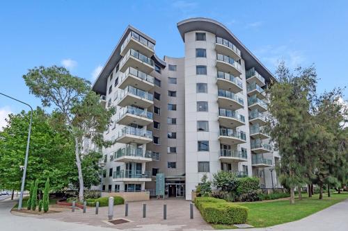 a tall white building with a rounded top at Central Braddon Retreat with Balcony & Pool Access in Turner