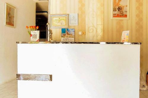 a white counter top in a room with flowers at RedDoorz Syariah at Penginapan Eby Padang in Duku