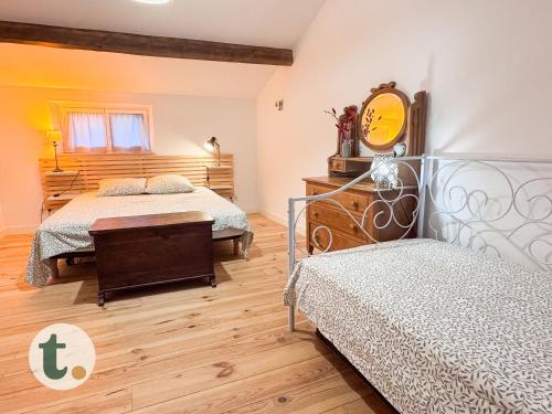 une chambre avec deux lits et un miroir au mur dans l'établissement Tranquiloue - Maison paisible à 7min du PuyduFou, aux Épesses