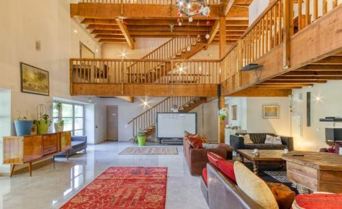 - un salon décloisonné avec des plafonds en bois et un escalier dans l'établissement Le Paradis, à Orcival