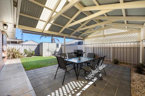 a patio with a table and chairs under a pergola at Moana Hideaway - 3BR, BBQ, Parking in Moana